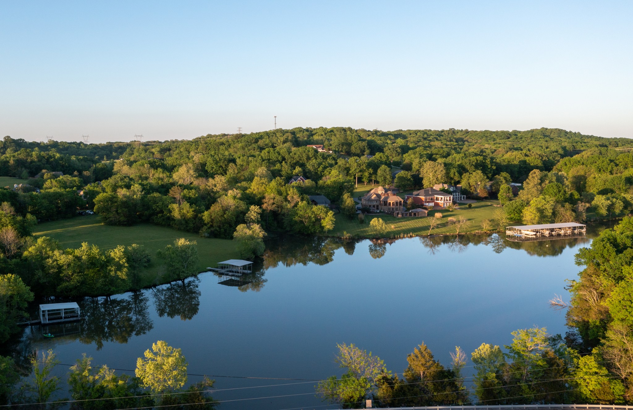 an aerial view of residential houses with outdoor space and lake view