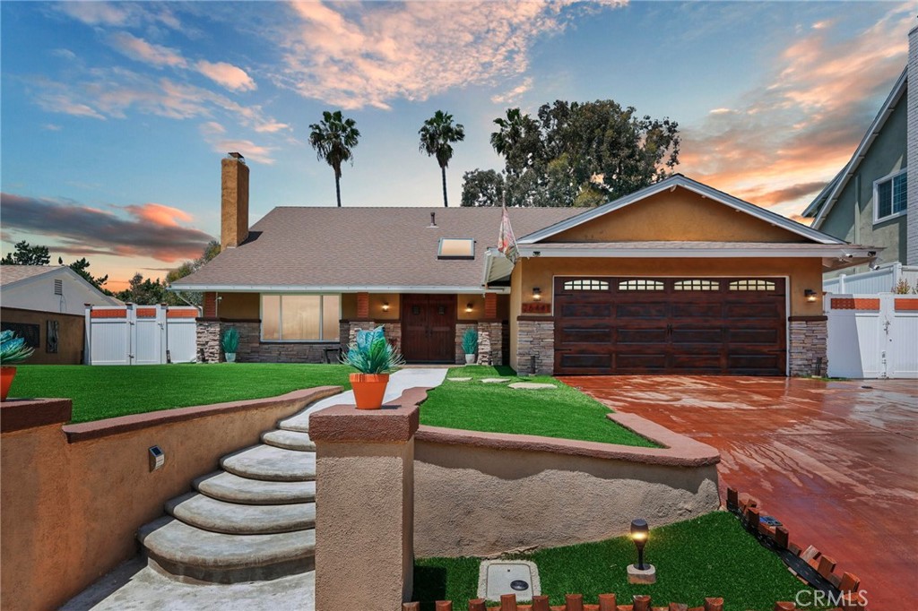 a front view of a house with a yard and trees