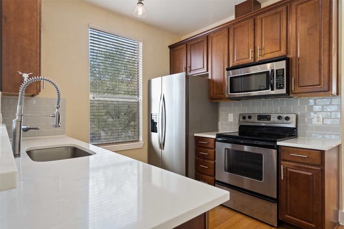 a kitchen with granite countertop a refrigerator stove and microwave