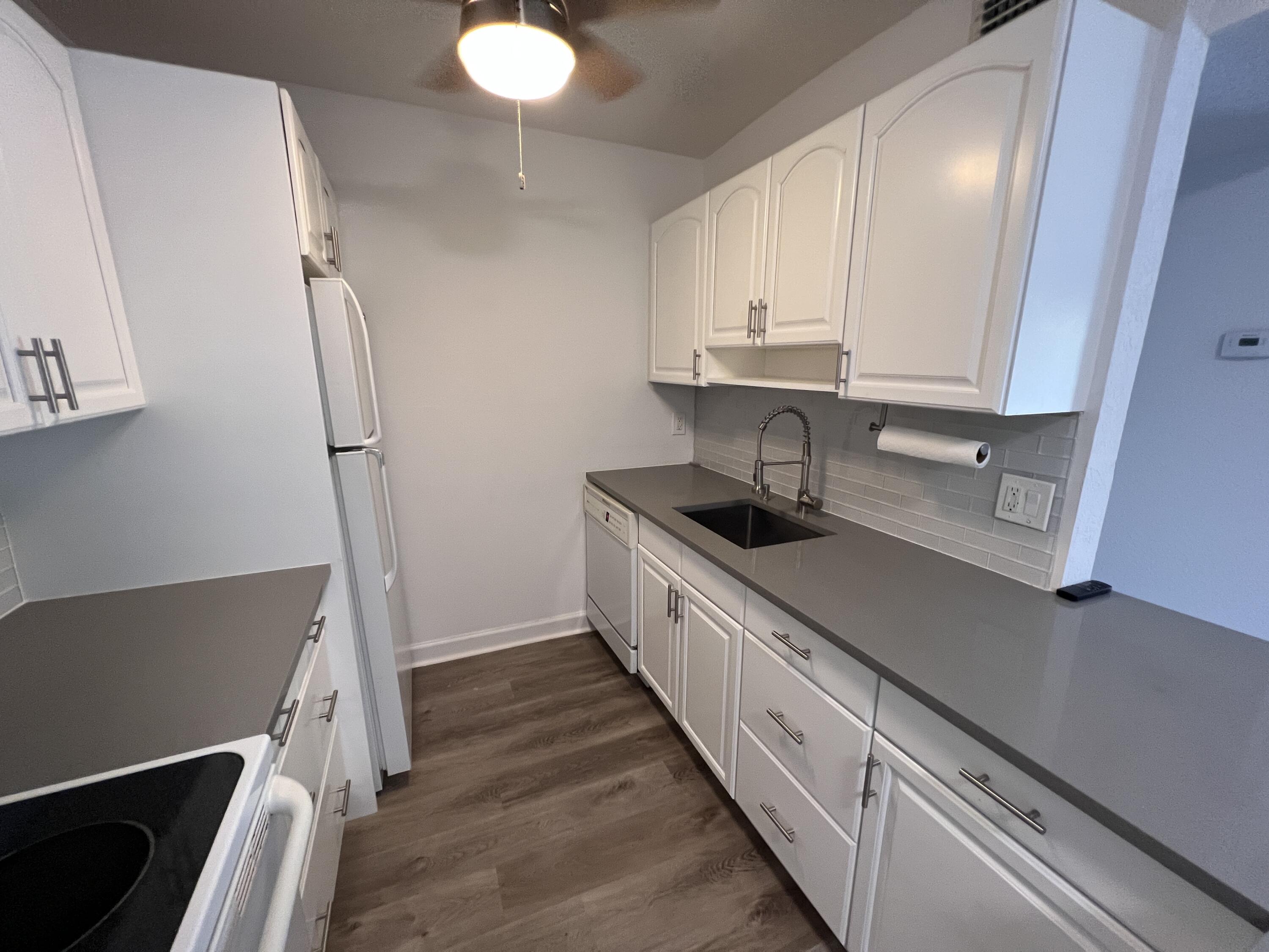 a kitchen with granite countertop white cabinets and sink