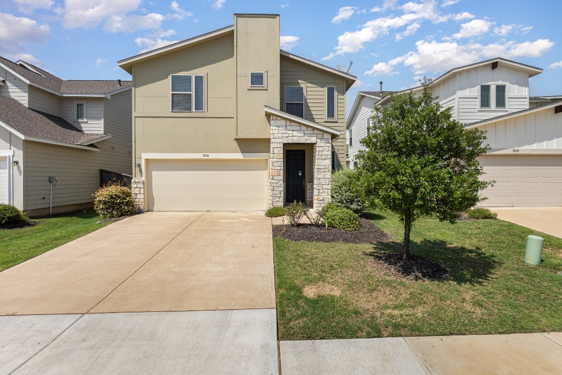 a front view of a house with a yard and garage