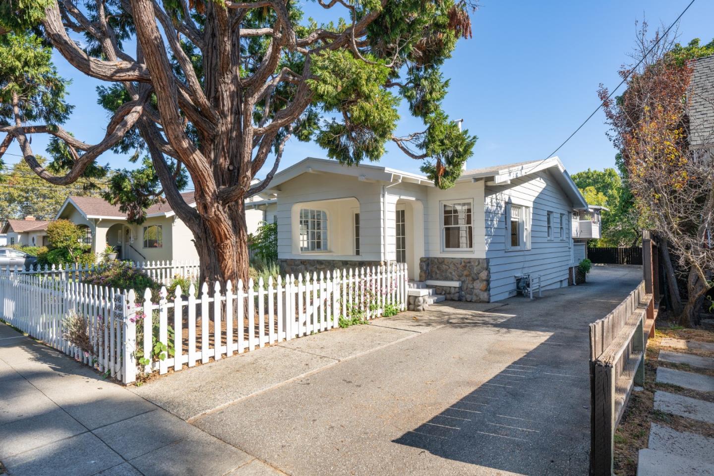 a front view of a house with a tree