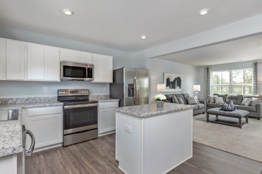 a kitchen with sink a microwave and refrigerator