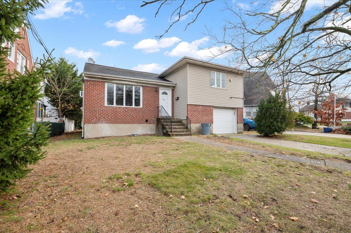 View of front facade featuring a garage and a front yard