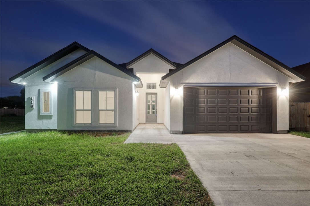 a front view of a house with yard and garage