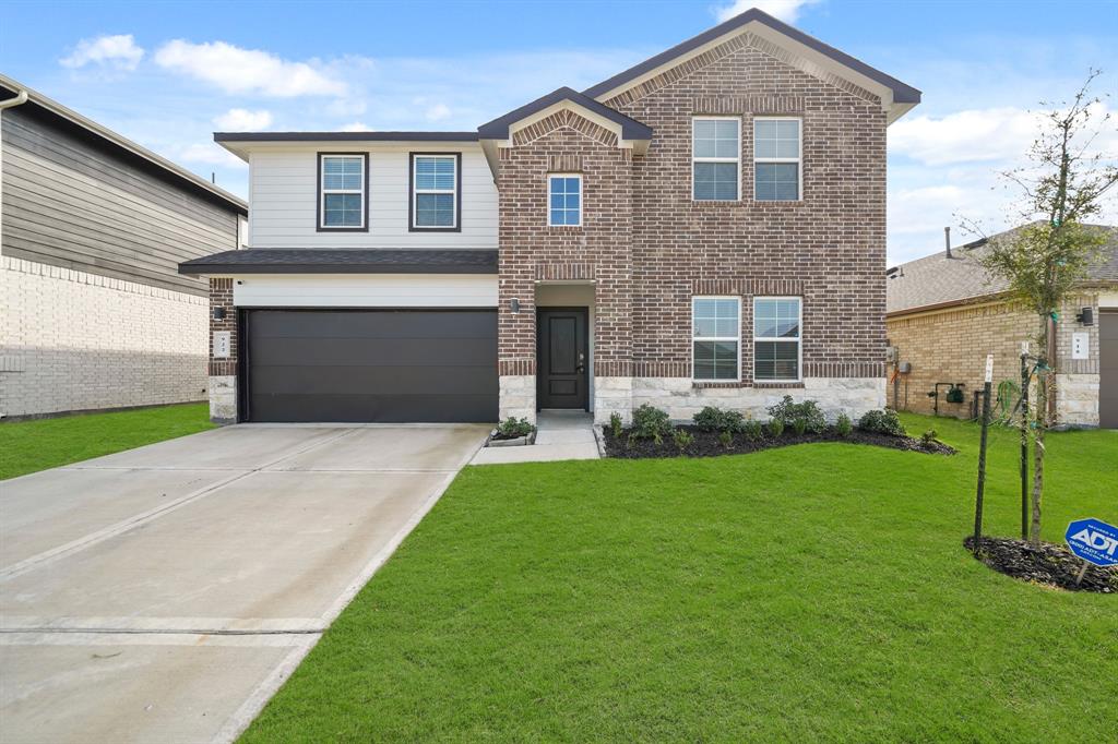 a front view of a house with a yard and garage