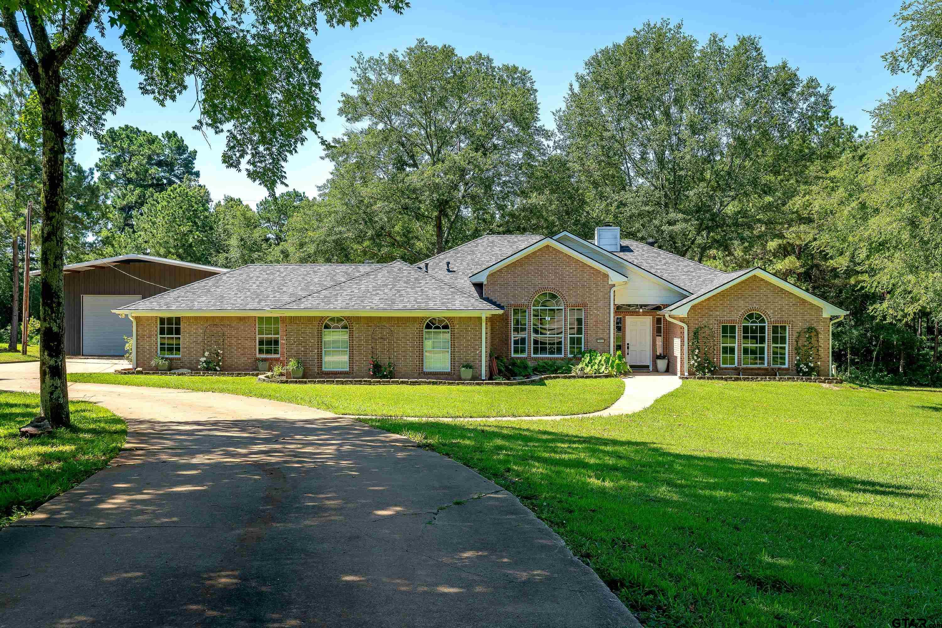 a front view of a house with a yard and trees