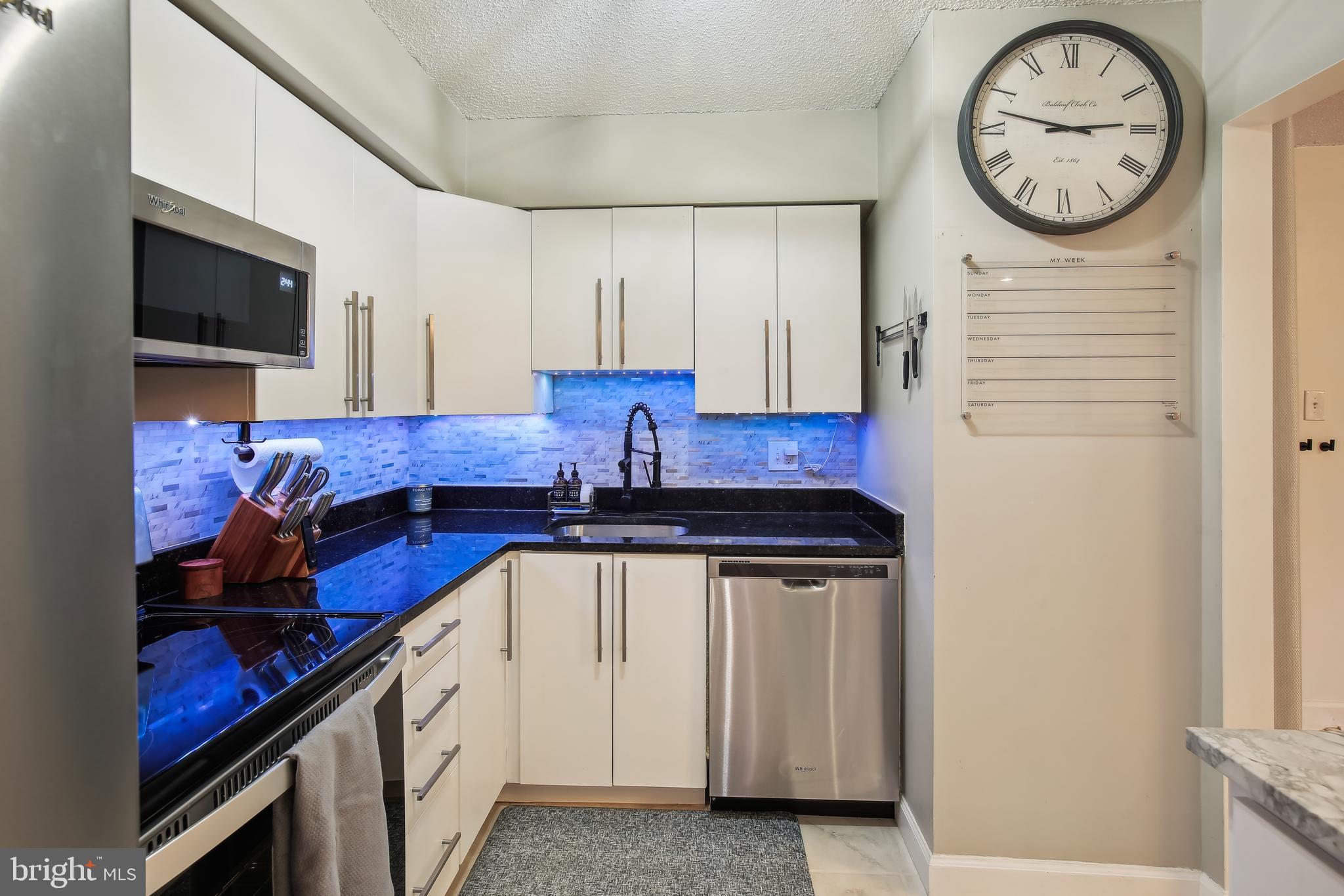 a kitchen with stainless steel appliances granite countertop a stove a sink and a microwave