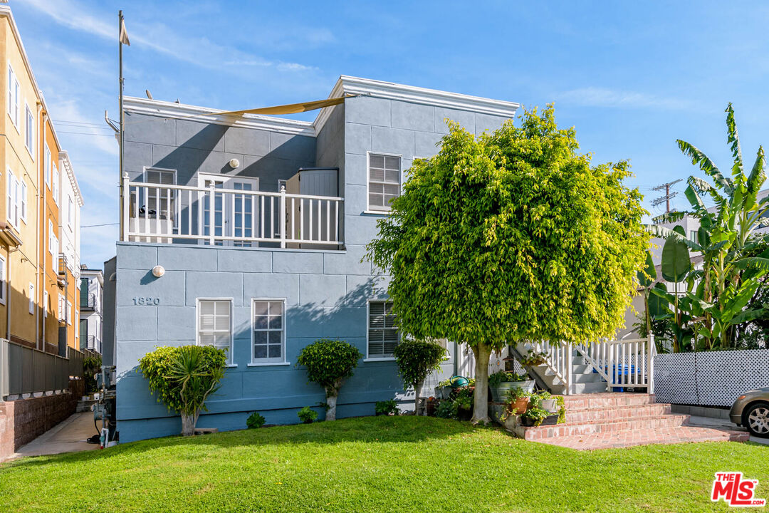 a view of an house with backyard and a tree