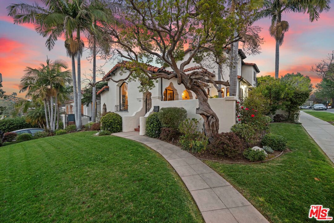 a couple of palm trees sitting in a yard with swimming pool