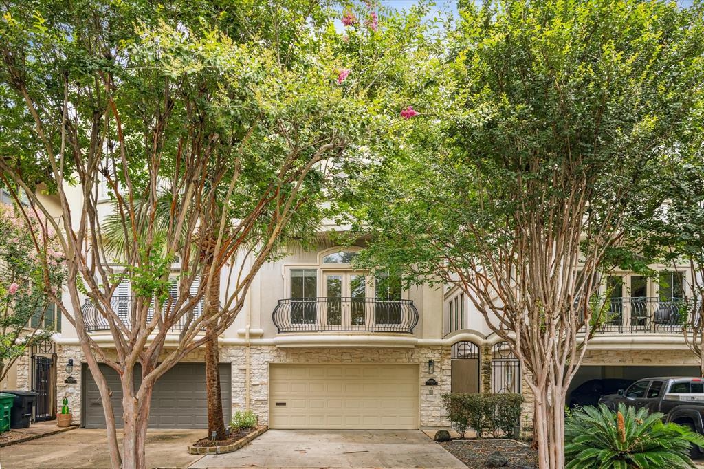 a front view of a house with a tree