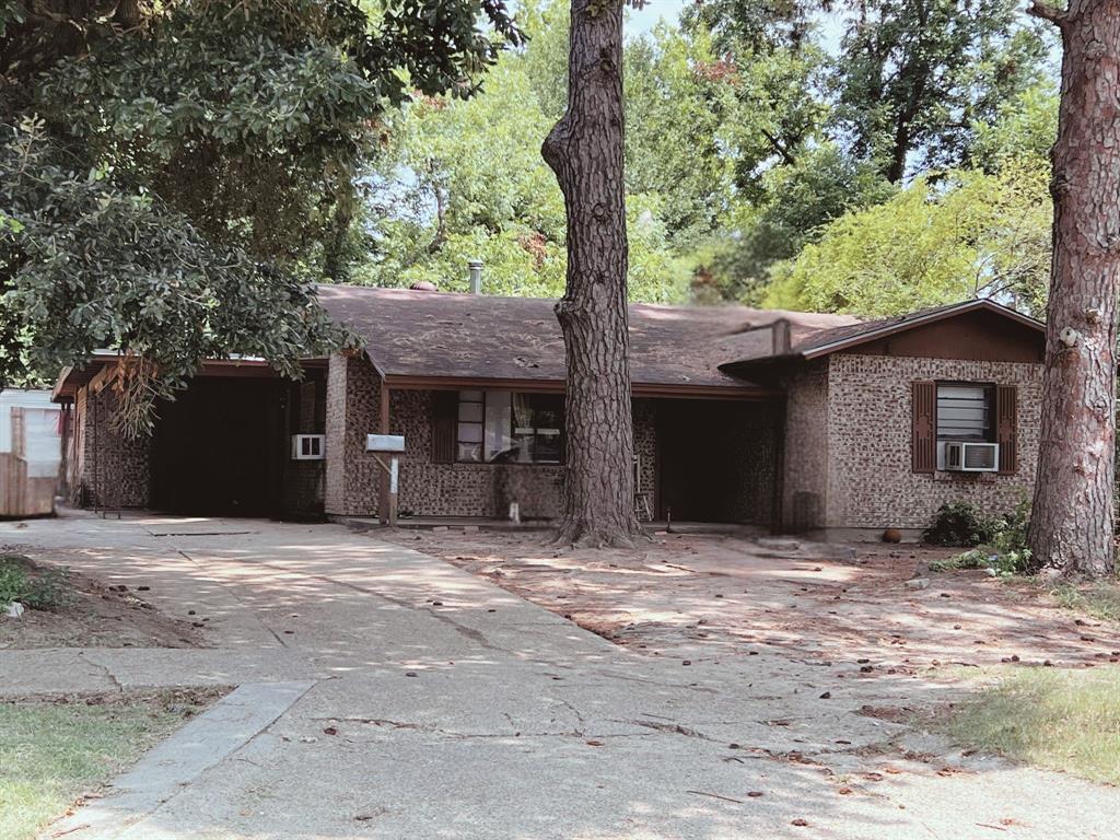 a front view of a house with a tree