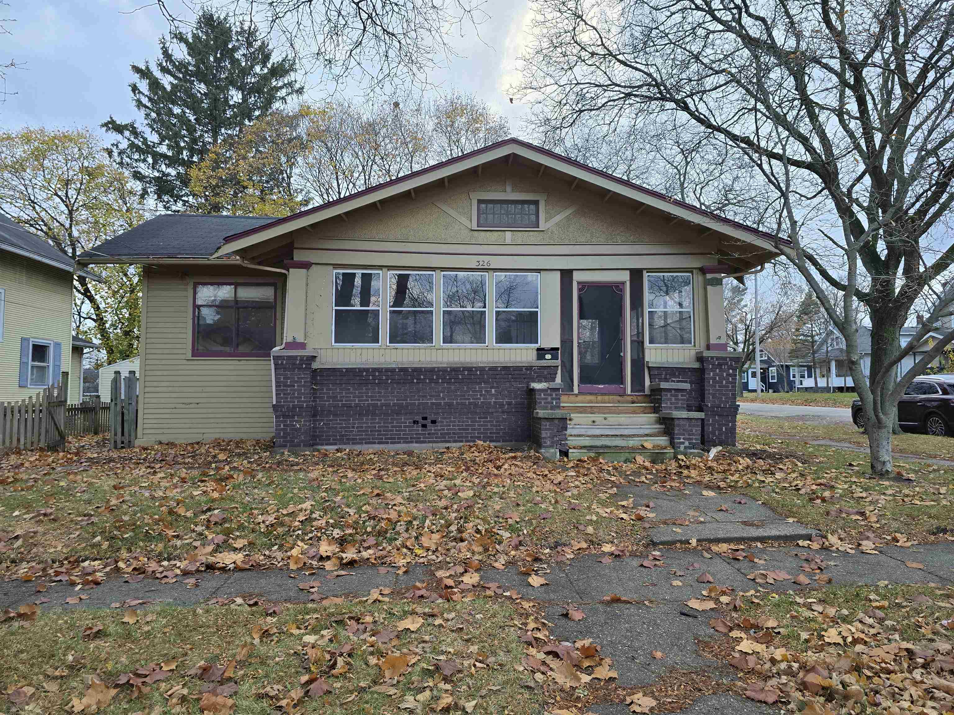 a front view of house with yard and trees in the background