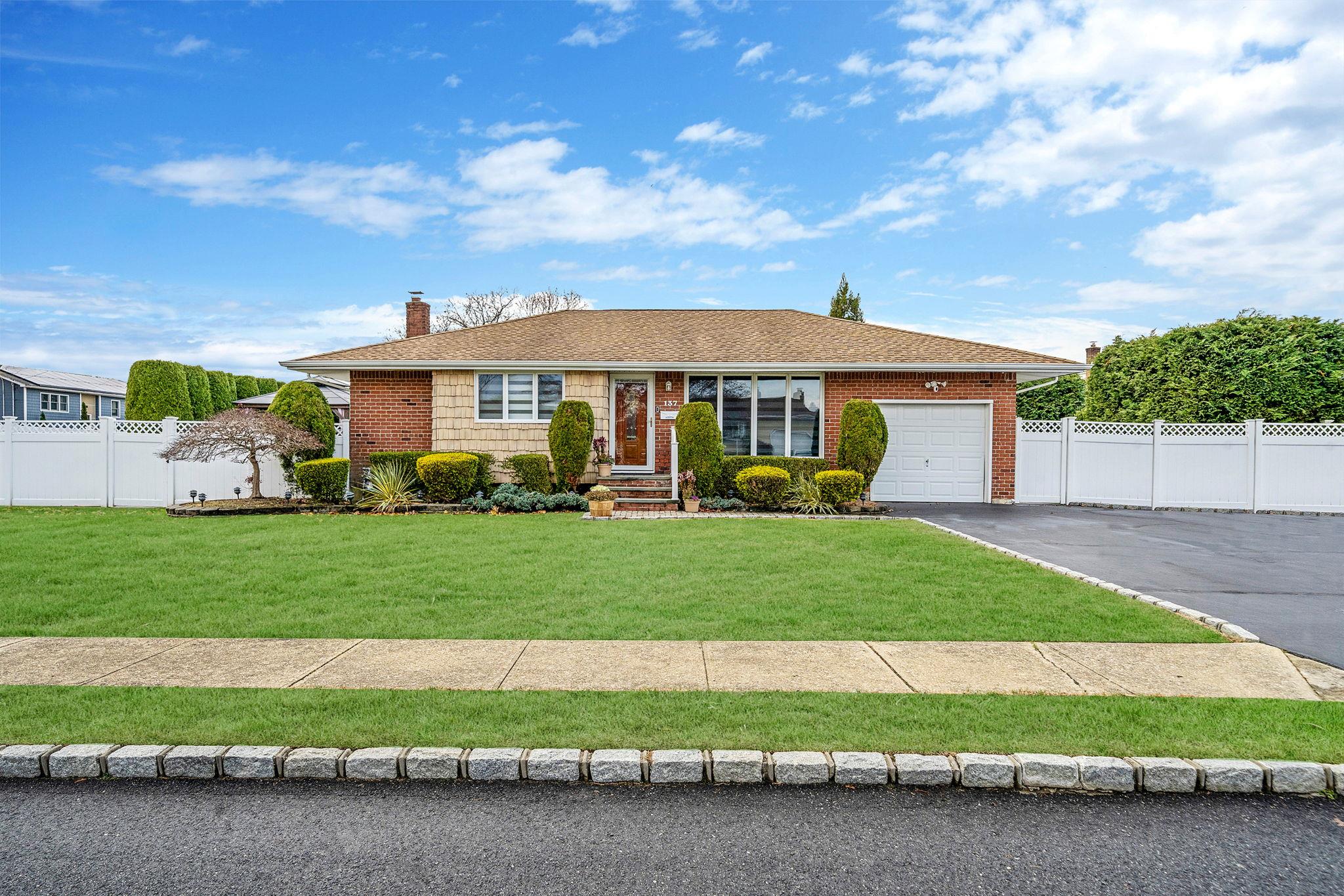 Ranch-style home featuring a garage and a front yard