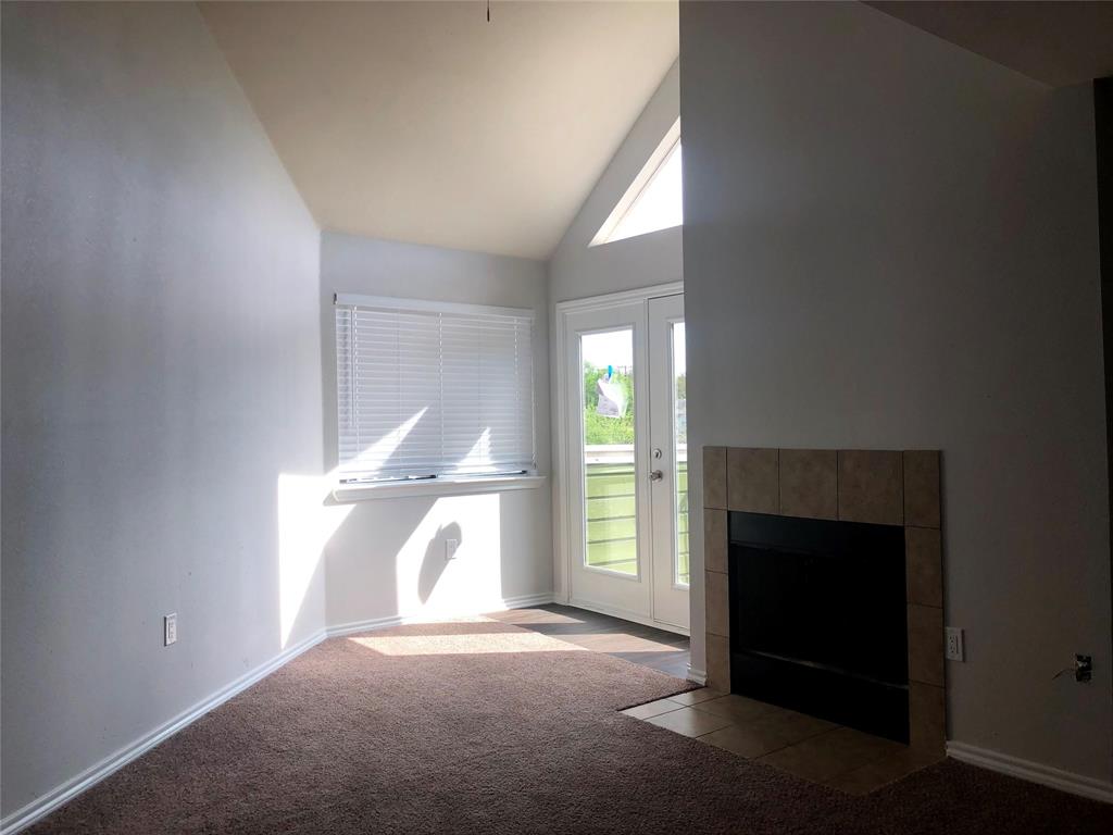 a view of empty room with a fireplace and window