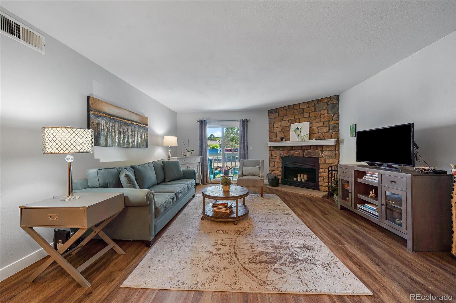 a living room with furniture a flat screen tv and a fireplace