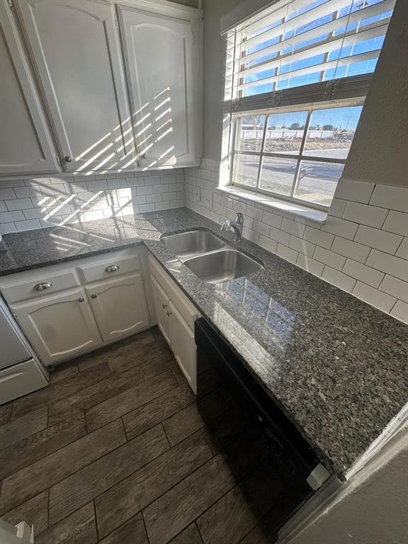 a kitchen with stainless steel appliances granite countertop a sink window and cabinets