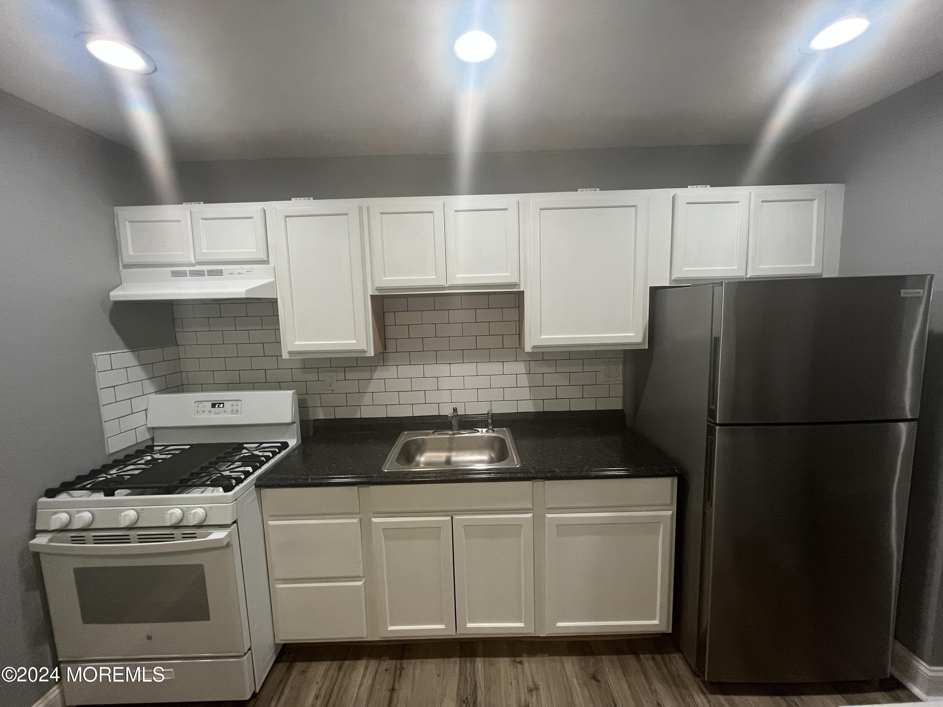 a kitchen with a refrigerator a stove a microwave and cabinets