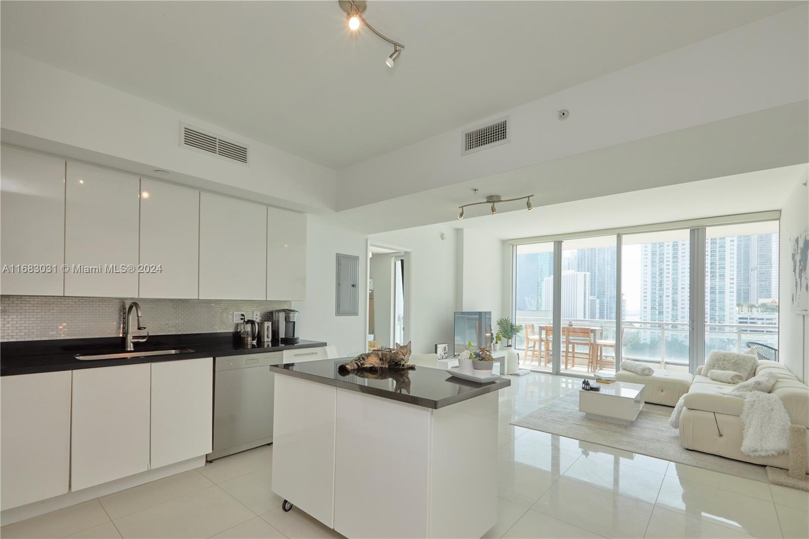 a kitchen with granite countertop a sink and white cabinets