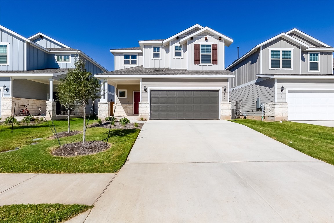 a front view of a house with a yard and garage