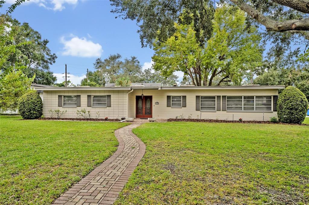 front view of a house and a yard with trees