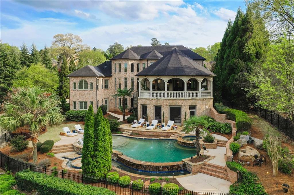 a front view of a house with a garden and lake view