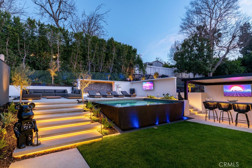 a view of a swimming pool with lawn chairs and a fire pit