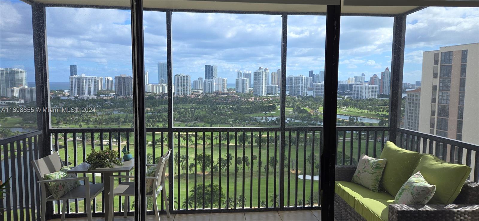 a view of a city from a balcony with furniture