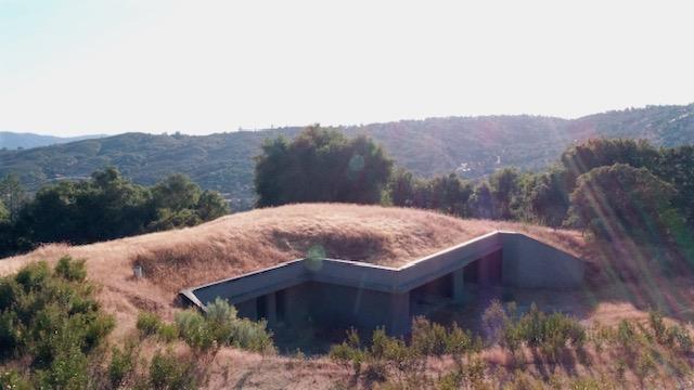 a view of a barn in a field with a mountain in the background