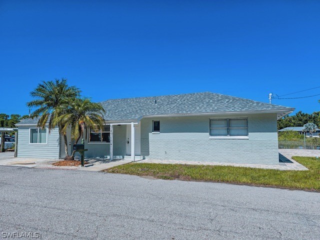 a view of a house with a yard and palm trees