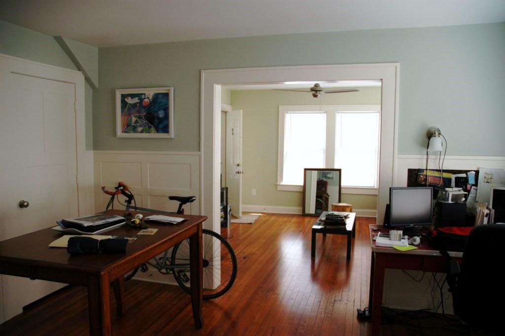 a view of a workspace with furniture and wooden floor