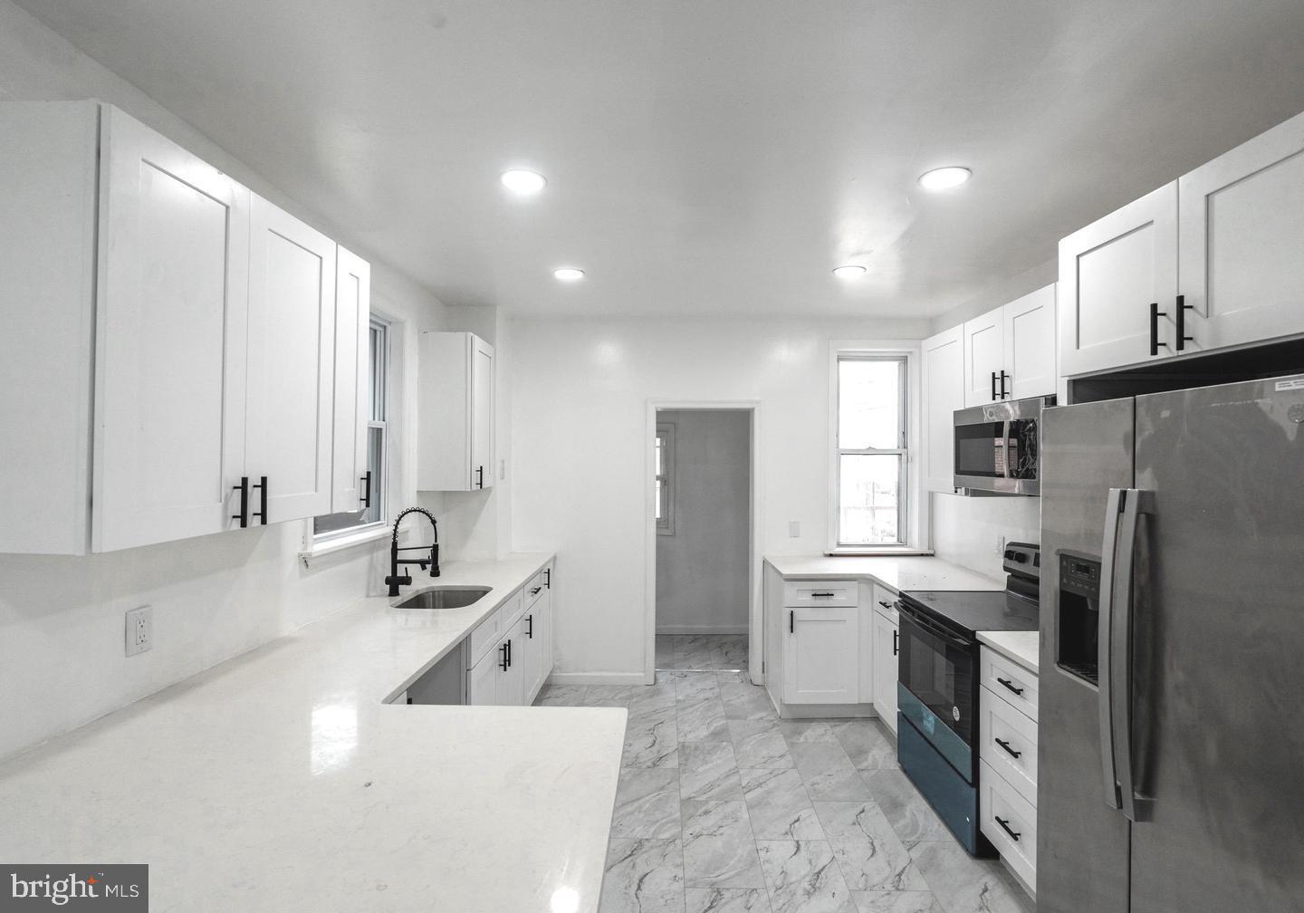 a kitchen with stainless steel appliances a refrigerator sink and cabinets