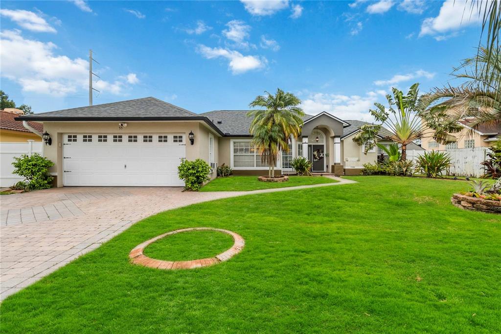 a view of a big house with a big yard and potted plants