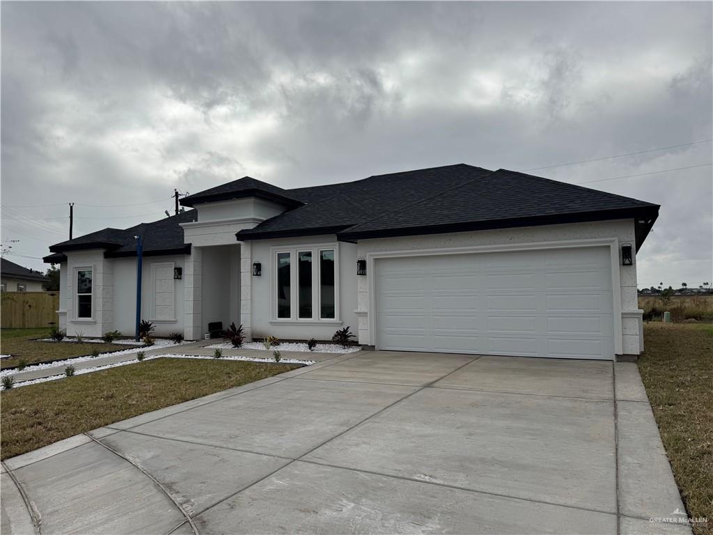 View of front of house featuring a front yard and a garage