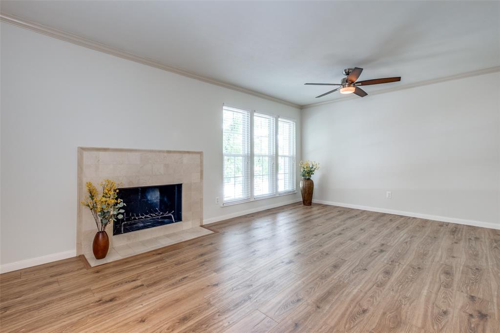 a view of an empty room with a fireplace and a window