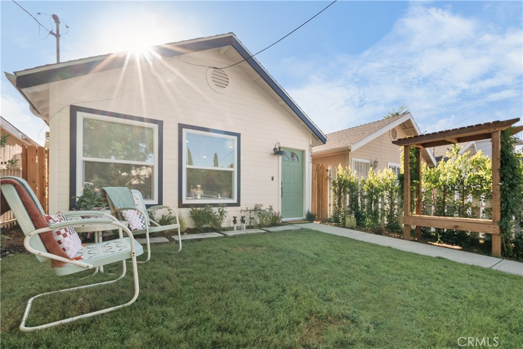 a very nice looking house with a big yard and dining table and chairs