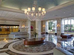 a view of a dining room with furniture a chandelier and large window