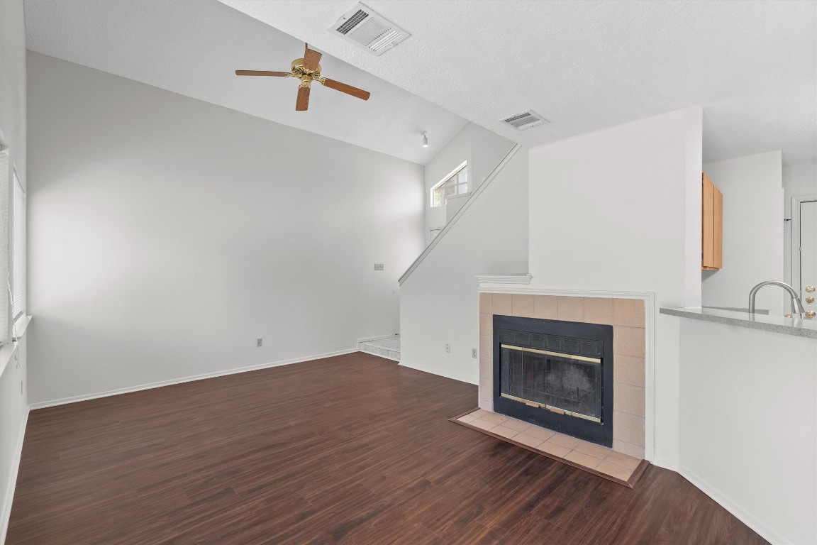 an empty room with wooden floor a fireplace