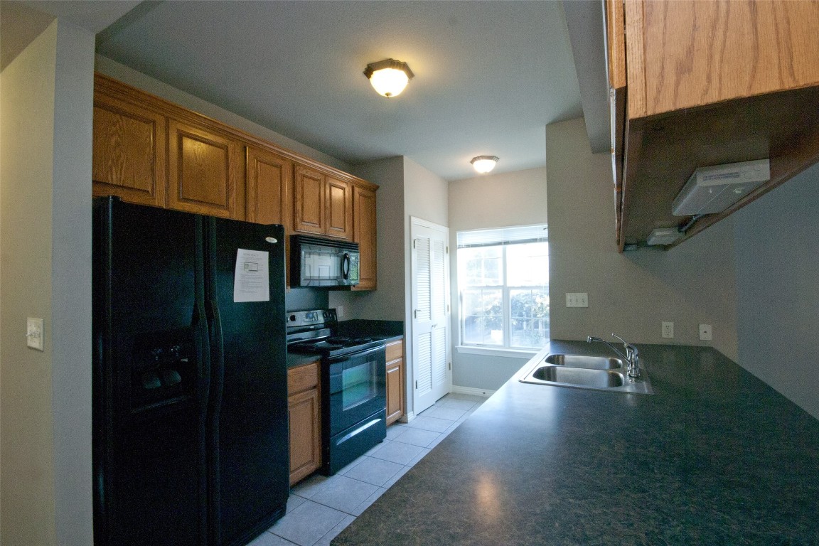 a kitchen with granite countertop a stove and a refrigerator