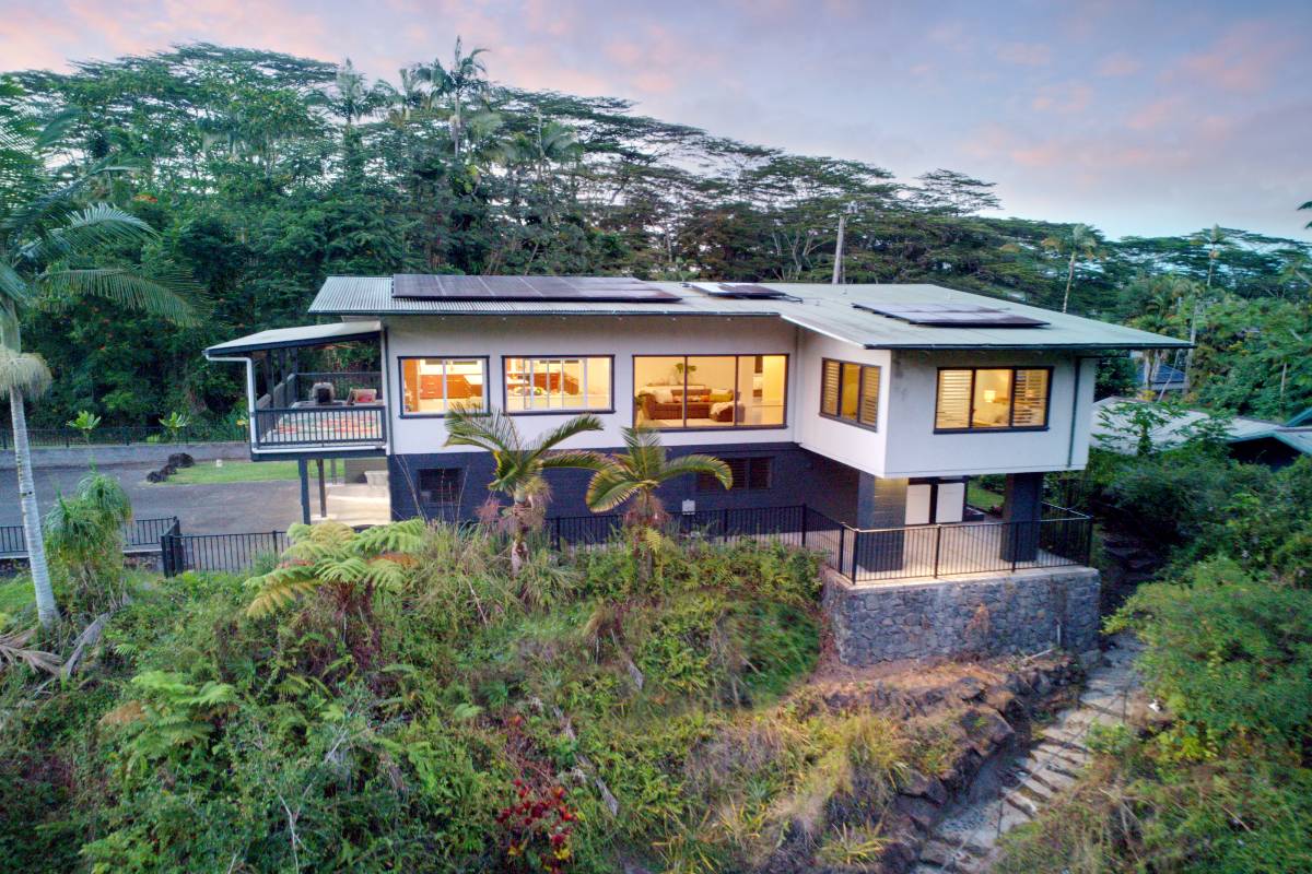 an aerial view of house with swimming pool and green space