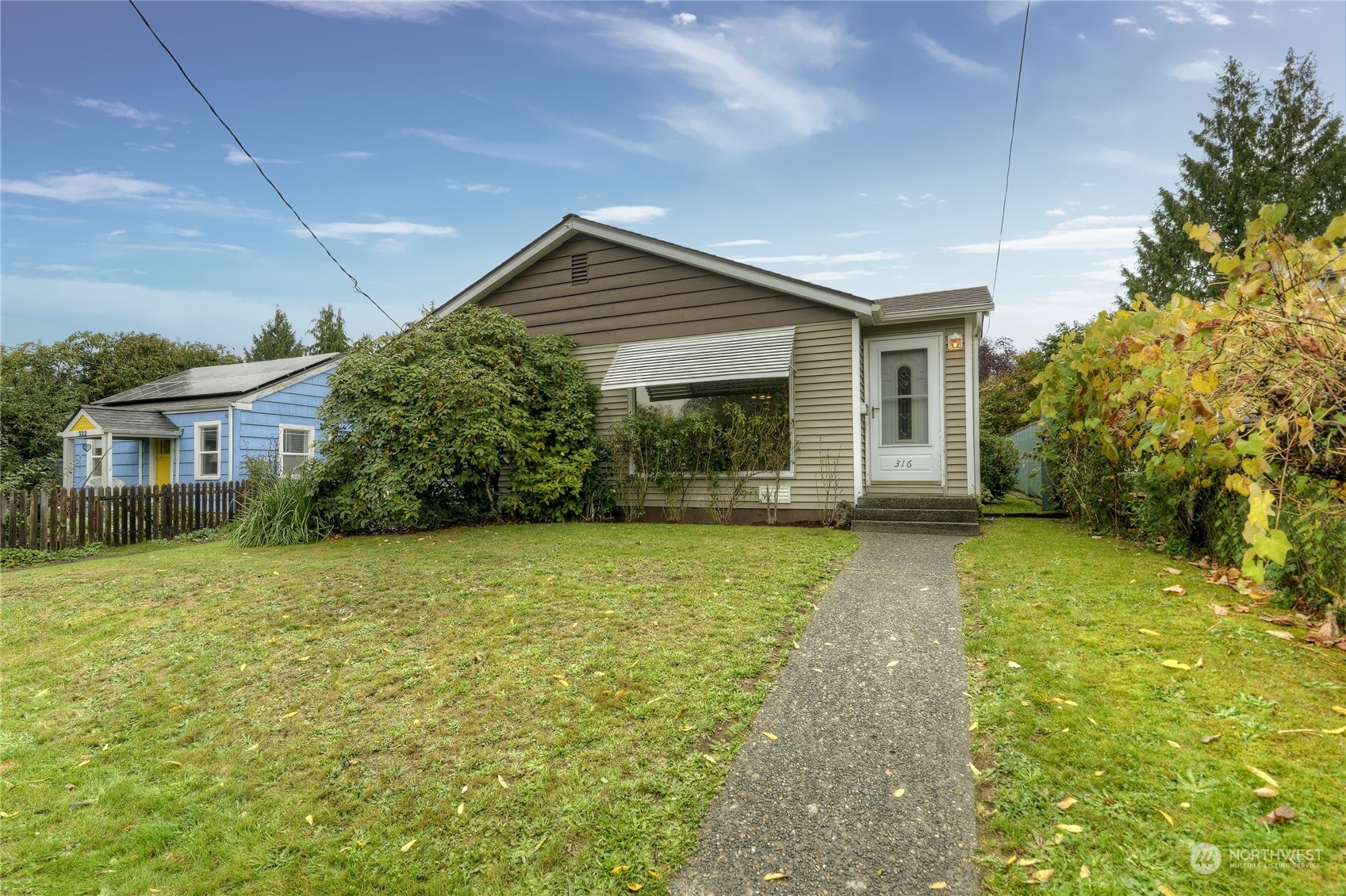 a front view of house with yard and trees in the background