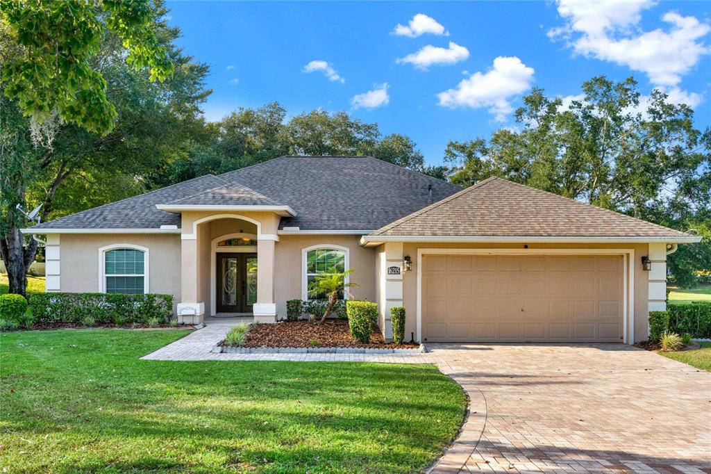 a front view of a house with yard and green space