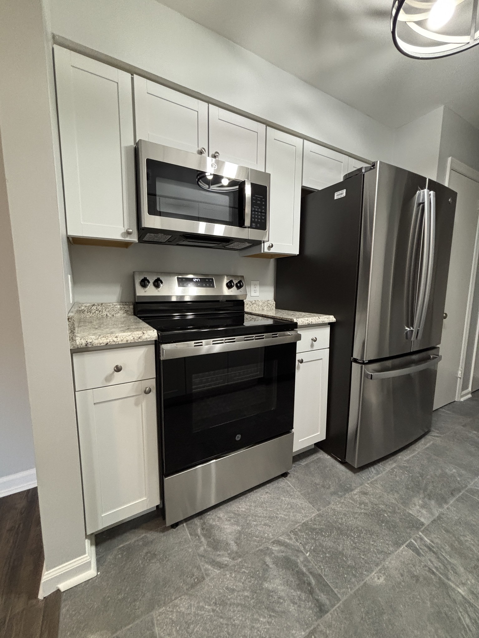 a kitchen with stainless steel appliances granite countertop a stove a refrigerator and a microwave