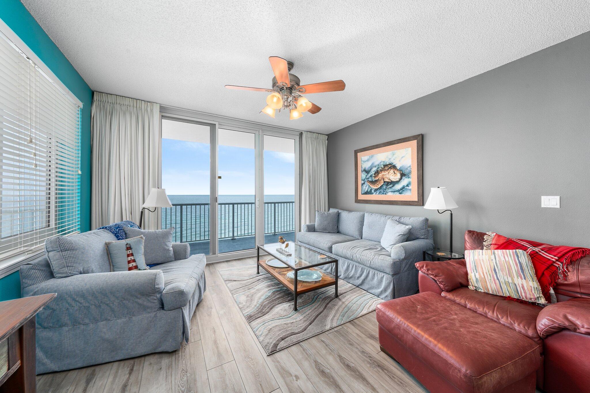 a living room with furniture ceiling fan and a large window