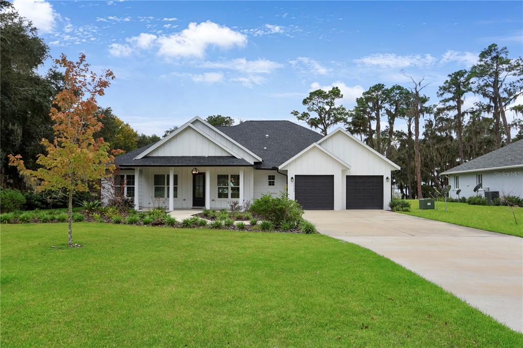 a front view of a house with a garden and trees