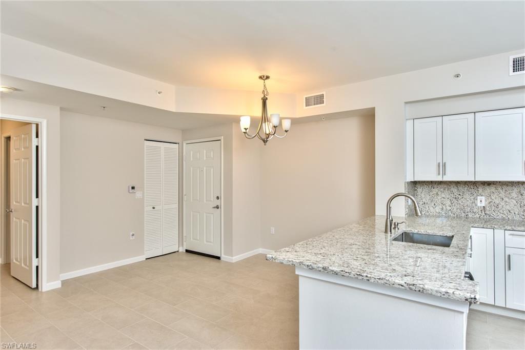 a kitchen with stainless steel appliances granite countertop a sink refrigerator and cabinets