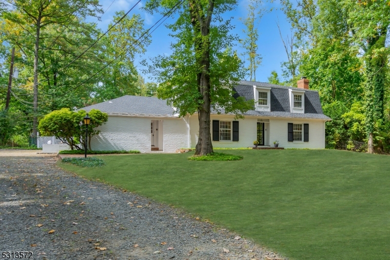 a front view of a house with a yard and trees