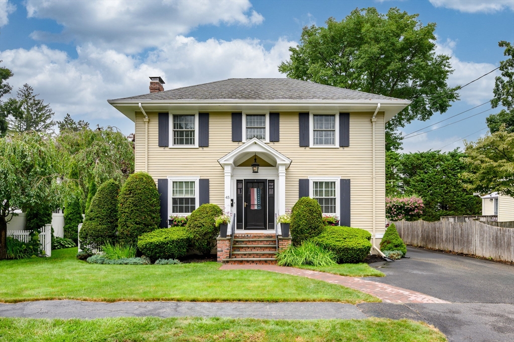 a front view of a house with a garden and yard