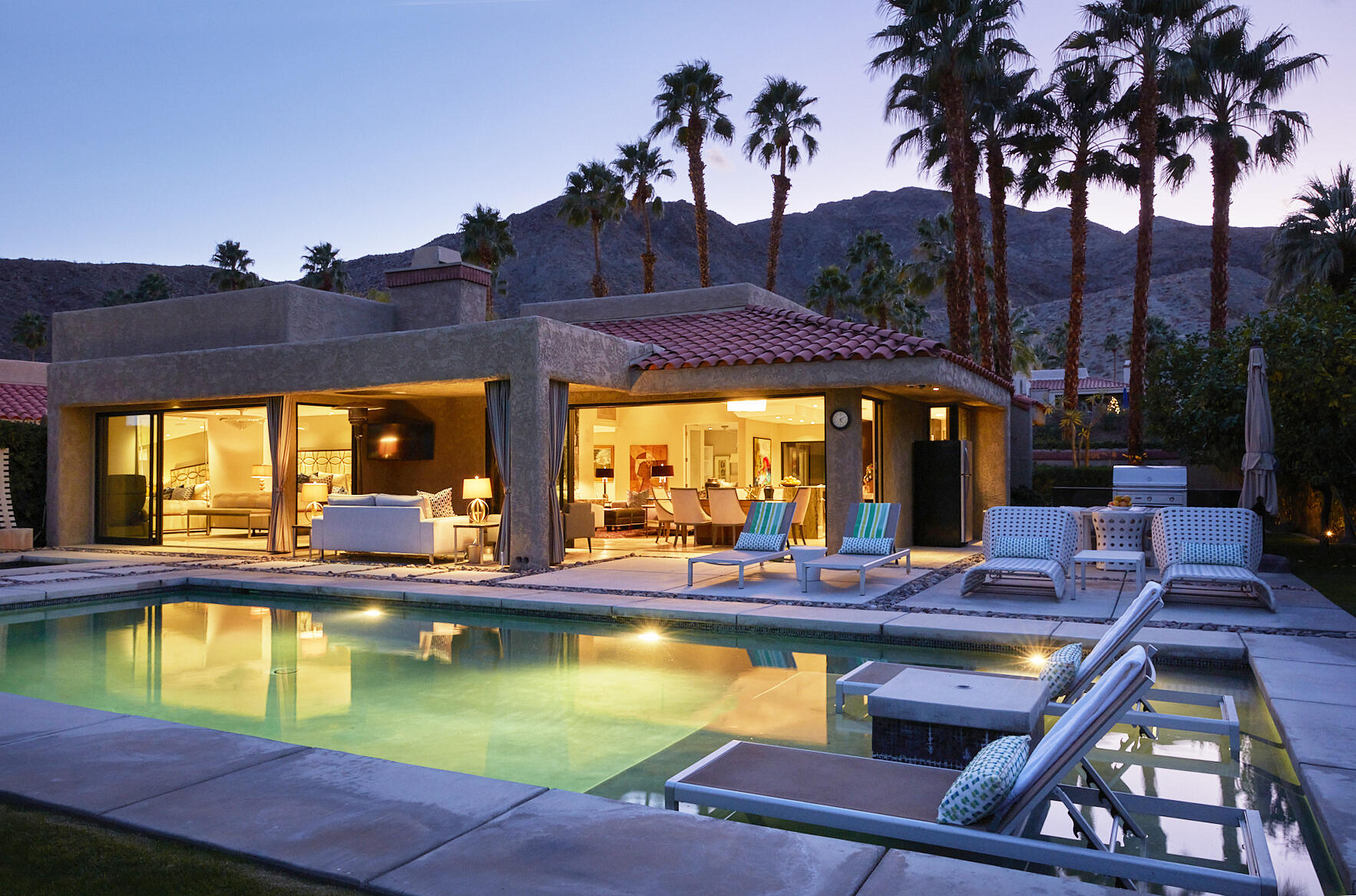 a view of an house with swimming pool and porch with furniture