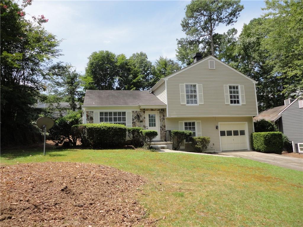 a front view of a house with yard and green space